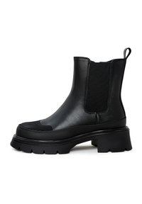 Bottes Chelsea noires avec une finition brillante, panneaux latéraux élastiques et une semelle épaisse et texturée. Onglet de tirage intégré à l'arrière pour un enfilage facile.