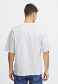 Hvid T-shirt med korte ærmer lavet af bomuld, med lige pasform og rund hals. Bagsiden viser et ensartet design uden grafik.