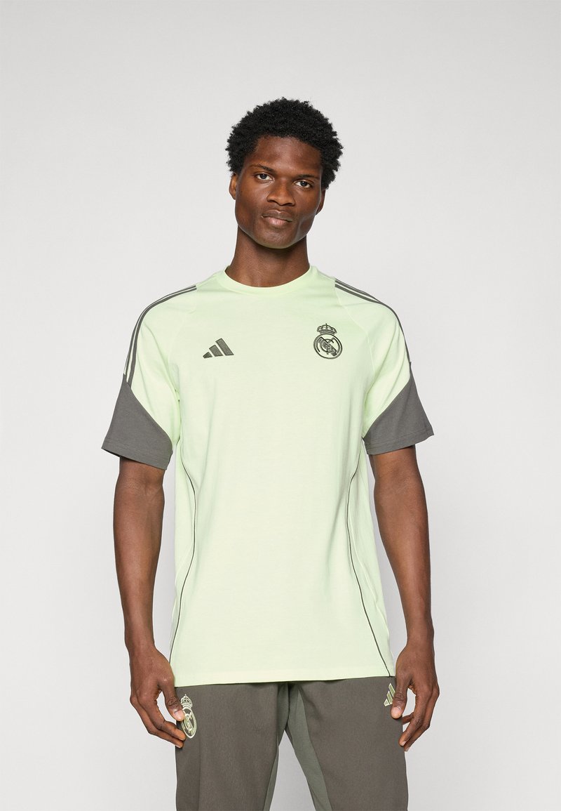 Lysegrøn atletisk t-shirt med grå korte ærmer, med Real Madrid-logoet og Adidas-branding. Lavet af glat stof, med rund hals design.