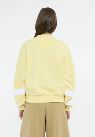 Gul sweatshirt med afslappet pasform, hvide kantstriber på ærmerne, ribbet manchetter og kant, med en glat overflade.