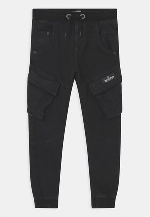 Pantalones jogger cargo negros con cintura elástica, cordón ajustable, bolsillos laterales con solapa, bolsillos frontales y una etiqueta de marca en la solapa del bolsillo derecho.