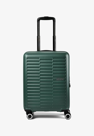 Maleta rígida de color verde oscuro con ranuras horizontales, asa negra retráctil, cuatro ruedas y logo de American Tourister en la parte delantera.