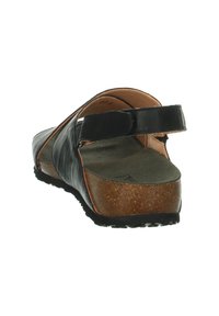 Schwarze Ledersandale mit Korksohle, ausgestattet mit einem breiten Riemen und einem verstellbaren Hinterriemen. Strukturierter Fußbett und gemusterte Laufsohle.