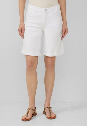 Shorts en denim blanc avec ourlets roulés, dotés de poches avant et de quincaillerie argentée. Associés à des sandales à imprimé animal en brun.