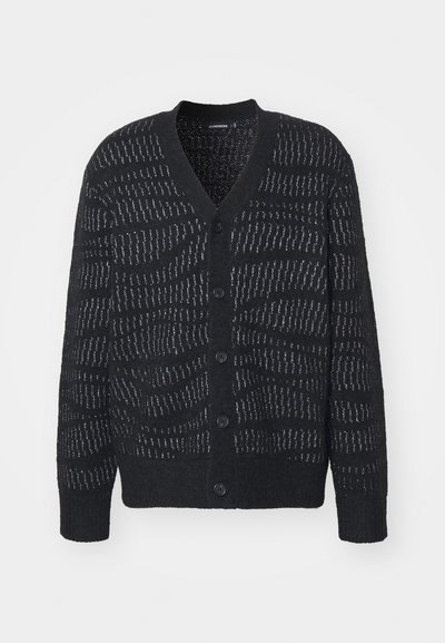 Μαύρο cardigan με υφασμάτινο σχέδιο, με βαθύ V λαιμόκοψη, έξι κουμπιά και ριγέ μανσέτες. Το χαρακτηριστικό υφαντό σχέδιο προσφέρει μία διακριτική λεπτομέρεια.