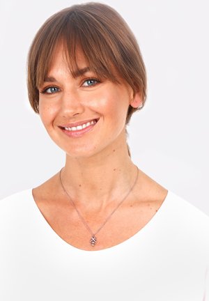 Silver necklace with a floral pendant, worn on a bare neck, against a white background. Smooth metal texture, delicate chain design.