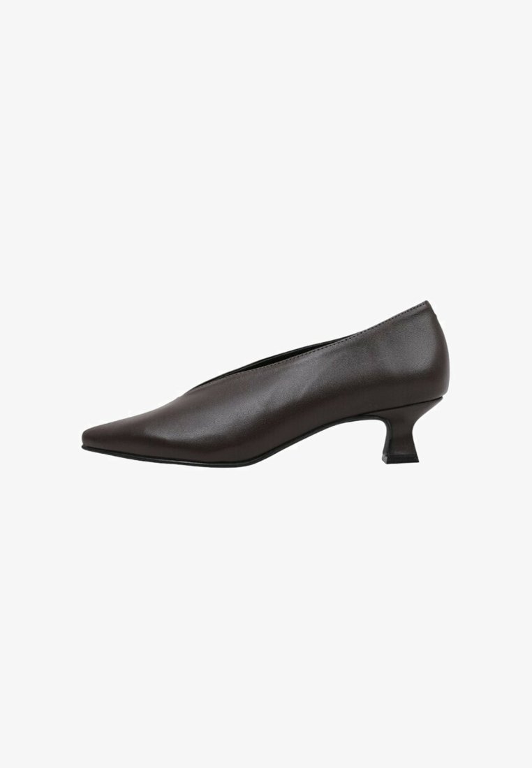 Zapato de tacón negro, con punta afilada, hecho de cuero liso. Presenta un diseño elegante con un tacón bajo tipo bloque y acentos mínimos.