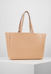 Perzikkleurige schoudertas van gestructureerd leer, met twee handvatten en een gestructureerde rechthoekige vorm met een gladde afwerking.