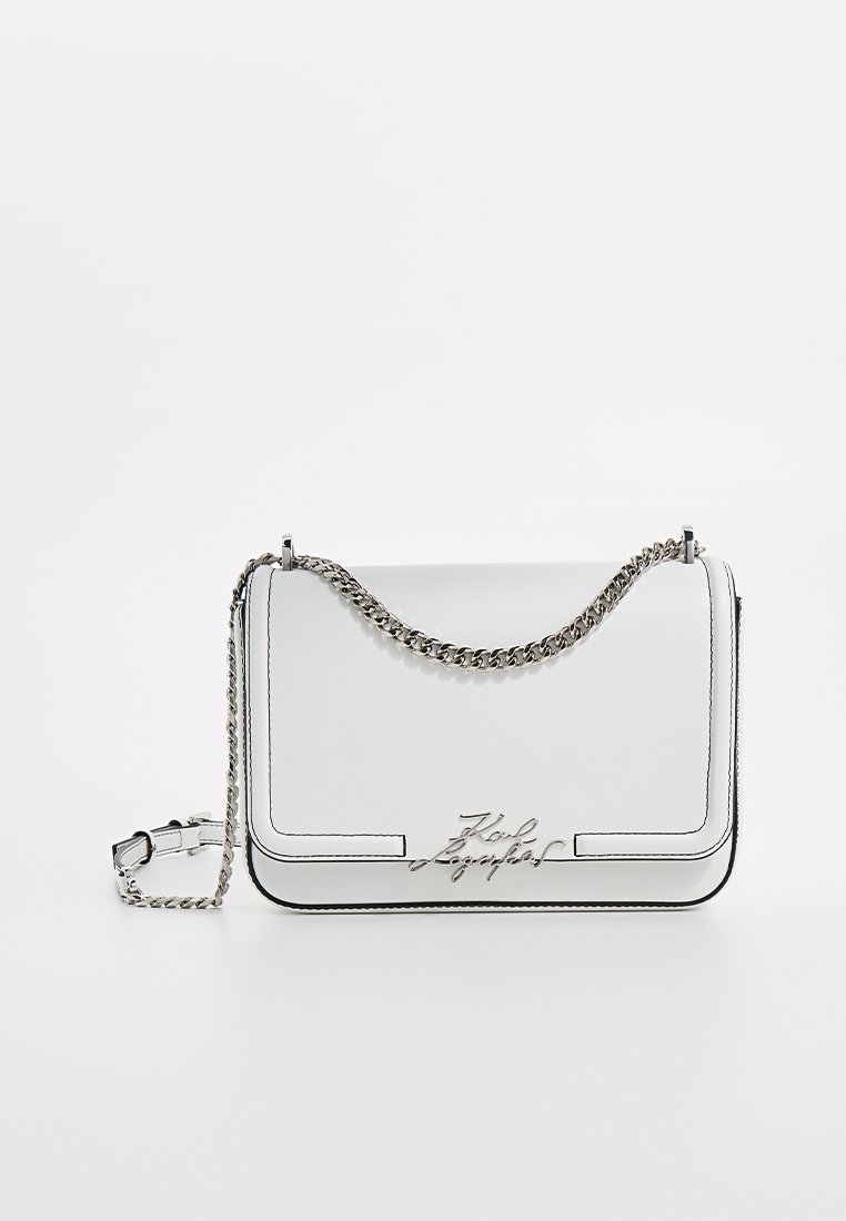 Sac à épaule en cuir blanc avec une chaîne argentée, présentant un logo distinctif à l'avant et des coutures noires le long des bords.