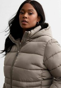 Ljus taupe puffer-jacka med huva, med horisontell sömnad, en framzipper och en mjuk innerskikt.