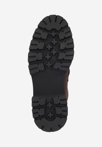 Black rubber outsole with deep treads and patterns for traction; brown leather side panel visible, indicating a rugged footwear design.