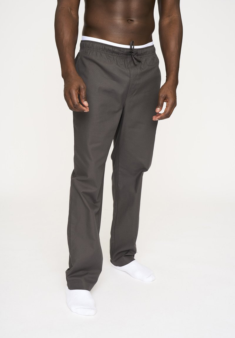 Gray relaxed-fit pants with an elastic waistband and drawstring, featuring a smooth texture. Paired with white ankle socks.