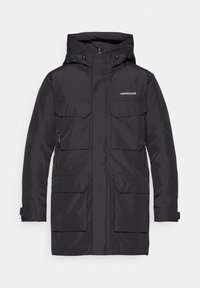 Svart vattentät parkas med huva, två stora framfickor, en sidoficka med dragkedja och ett flexibelt material för värme.