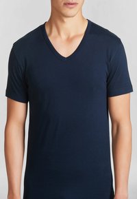 T-shirt blu navy a maniche corte con scollo a V, realizzato in tessuto morbido, design aderente con texture liscia e dettagli di cucitura minimi.