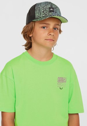 Neon grøn t-shirt med korte ærmer og et lille lilla logo på brystet. Sammen med en sort mesh-cap med et geometrisk mønster.