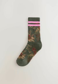 Grøn sok med blomsterdesign i rød og beige. Har en ribbet manchet med to pink vandrette striber øverst. Blød stofstruktur.