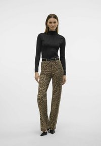 Zwarte geribbelde langemouwtop gecombineerd met hoge taille broek met luipaardprint. De broek heeft een rechte snit; het model draagt zwarte puntige hakken.