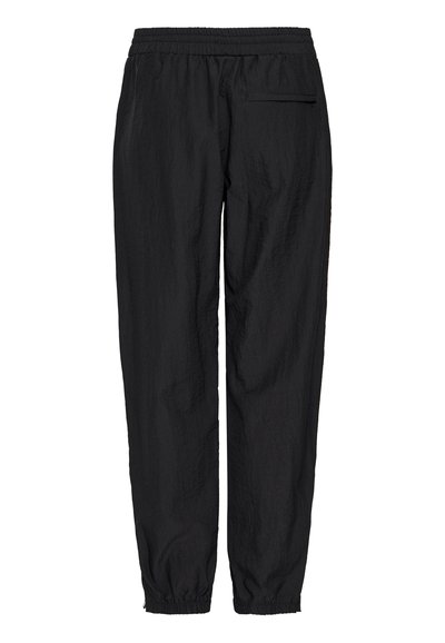 Schwarze, leichte, elastische Hosen mit gerafften Knöcheln. Besitzt eine einzige hintere Reißverschlusstasche und eine strukturierte Oberfläche.