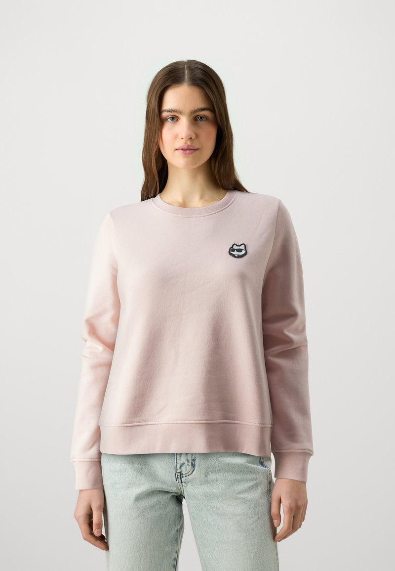 Felpa rosa chiaro in cotone con collo rotondo e maniche lunghe. Presenta un piccolo logo ricamato di un gatto in bianco e nero.