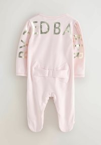 Lyserød langærmet heldragt med metallisk "BY TED BAKER" tekst på ærmerne, med en sløjfe detalje på ryggen og en blød, glat tekstur.