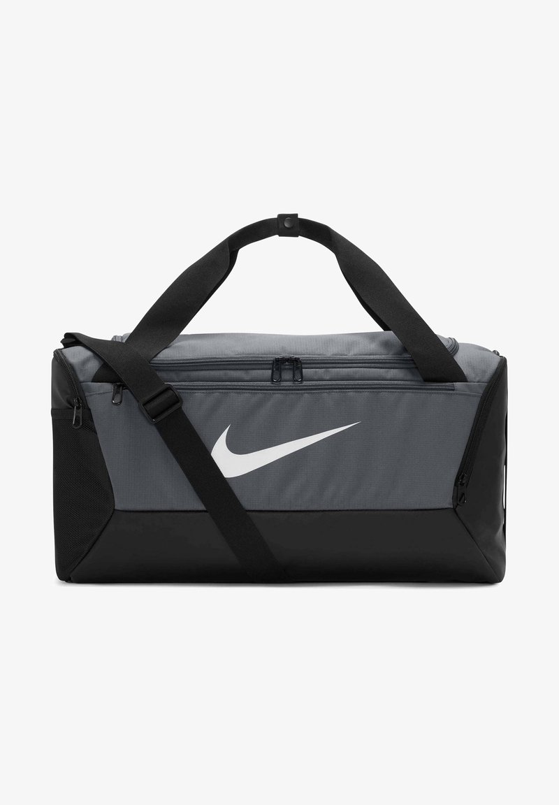 Borsa da viaggio Nike con un corpo in tessuto grigio, fondo nero, doppi manici, tracolla regolabile e un logo bianco sul davanti.