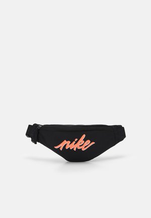 Black waist bag with adjustable strap and zip closure, featuring orange Nike logo in cursive font on front.