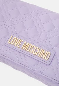 Lilak kviltad läderpung med guld "LOVE MOSCHINO" logotavla i mitten på framsidan.
