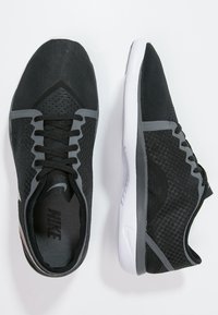 Black athletic shoes with mesh upper, gray accents, and a white outsole. Features a lace-up design and textured panels for breathability.
