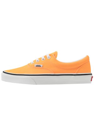 Oranžové plátěné tenisky s nízkým střihom a bílými tkaničkami, černou gumovou podešví a bílým proužkem jako akcentem. Na boku je logo Vans.