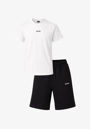 Maglietta bianca a maniche corte e pantaloncini neri con coulisse, entrambi con piccolo logo stilizzato bianco sul petto e sulla coscia.