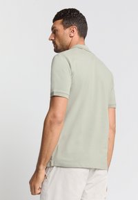 Korte mouwen polo shirt in lichtgroene katoen met een kraag en een rechte zoom. Heeft een effen ontwerp zonder zichtbare patronen of accenten.