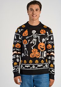 Czarny sweter z dzianiny z wielokolorowymi wzorami w tematyce Halloween, w tym szkielety, dynie i czaszki, z ściągaczami na mankietach i dolnym brzegu.