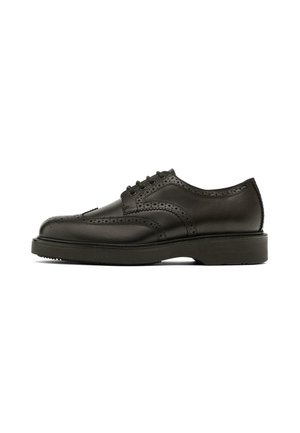 Black leather brogue shoes with decorative perforations, rounded toe, six eyelets, and a thick, textured rubber sole.