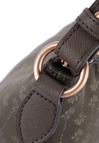 Brun mönstrad handväska med texturerad yta, som har en dekorativ ring i guldutförande och rem, samt präglad logotypdetalj.