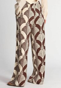 Pantaloni palazzo in tessuto crema con un motivo a ventaglio marrone e bianco. Vestibilità ampia con tasche laterali e una vita arricciata.