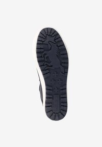 Semelle de chaussure en caoutchouc noir avec un motif de traction texturé, présentant un design de licorne en relief. Détails de bord blanc et de grip en motif croisé.
