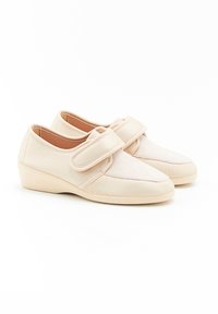 Scarpe in tessuto beige con cinturino in velcro, punta arrotondata e tacco basso a cuneo. Parte superiore testurizzata con fodera interna liscia.