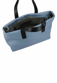 Sac fourre-tout synthétique bleu avec des poignées en cuir noir, doté d'un intérieur spacieux et d'un logo embossé à l'avant. Poche zippée incluse.