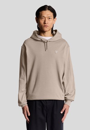 Beige bomulds hoodie med en frontlomme i kengurustil, snore i hætten og et lille logo på brystet. Løs pasform og lange ærmer.
