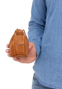 Braune Leder-Zugtasche mit abgerundetem Boden, strukturiertem Oberflächen und geprägt Logo. Handtragend, zeigt die kleine Größe und das schlichte Design.