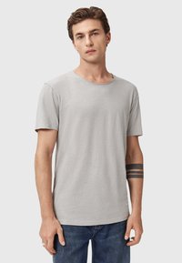 T-shirt grigio chiaro a maniche corte in morbido tessuto, con scollatura rotonda e vestibilità comoda. Presenta dettagli cuciti lungo i bordi.