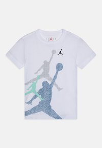 Biała bawełniana koszulka z wielokolorowymi sylwetkami koszykarzy w odcieniach niebieskiego, zielonkawo-niebieskiego i szarego, z małym czarnym logo przy dekolcie.