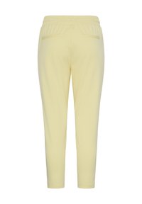 Pantalon fuselé jaune clair avec taille élastique et deux poches fendues à l'arrière, présenté sur fond blanc.