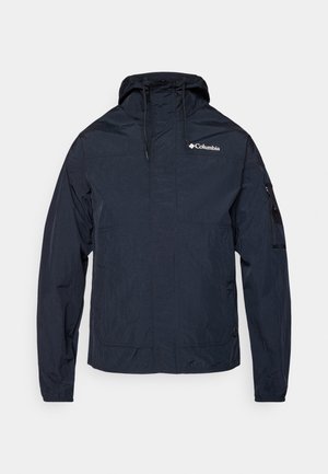 Navy blue lightweight jacket, made of water-resistant material, with a hood, front zip, and logo on the left chest. Features adjustable cuffs.