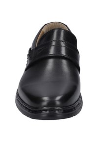 Musta nahkakengät, joissa on pyöreä varvas, sileä pinta ja leveä velcro-hihna jalkapöydän ympäri. Vahvistettu ommel pohjan ympärillä.