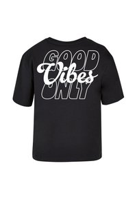 T-shirt noir avec une inscription audacieuse en lettres blanches au dos : "BONNES VIBRATIONS UNIQUEMENT". Manches courtes et coupe ample.