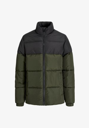 Must ja oliivrohelise värviga pufferjakk, kantud helehalli teksti sisaldava kapuutsiga üle. Komplekti kuuluvad laiad sinised teksad ja beežid jalatsid.