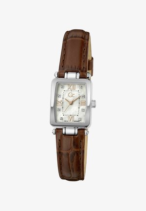 Montre carrée en argent avec bracelet en cuir marron, cadran blanc, chiffres romains à 12, 3, 6, 9, et index en cristal, affichant 10:08:20.