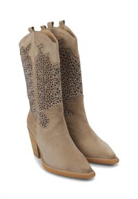 Botas de vaquero de ante en color beige, con un panel de cuentas brillantes en el caña, punta puntiaguda y tacón de madera apilada. Detalle de costuras decorativas.