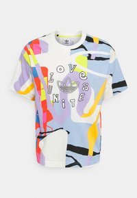Bomullströja med lös passform, med flerfärgade abstrakta mönster, rund halsringning och texten "LOVE UNITE" tillsammans med Adidas-logotypen.